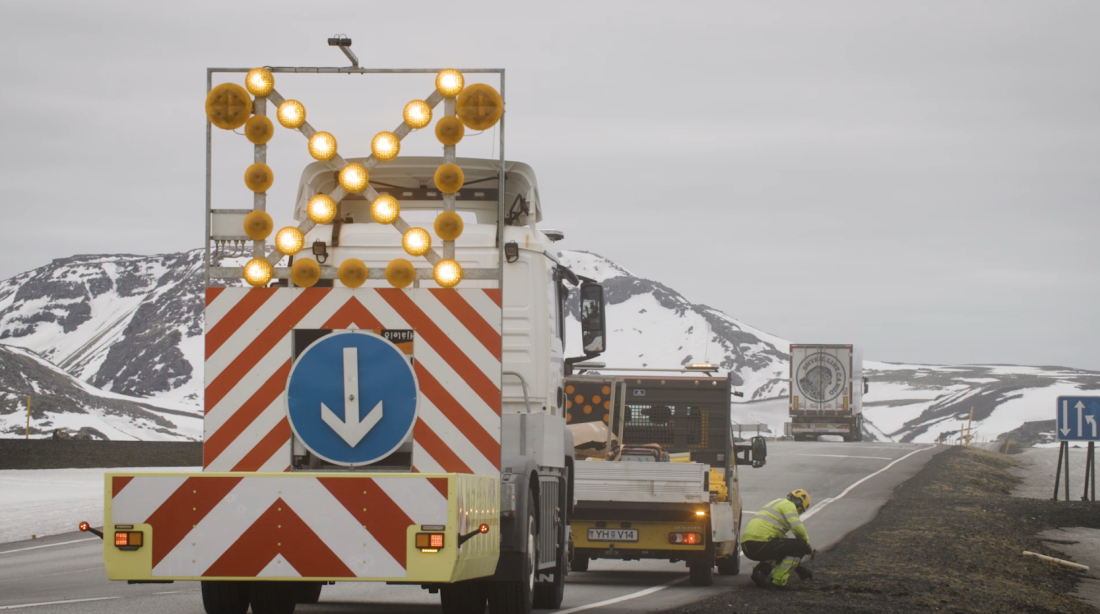 Öryggisbifreið með árekstrarpúða fylgir starfsmönnum Vegagerðarinnar við stikuvinnuna.

