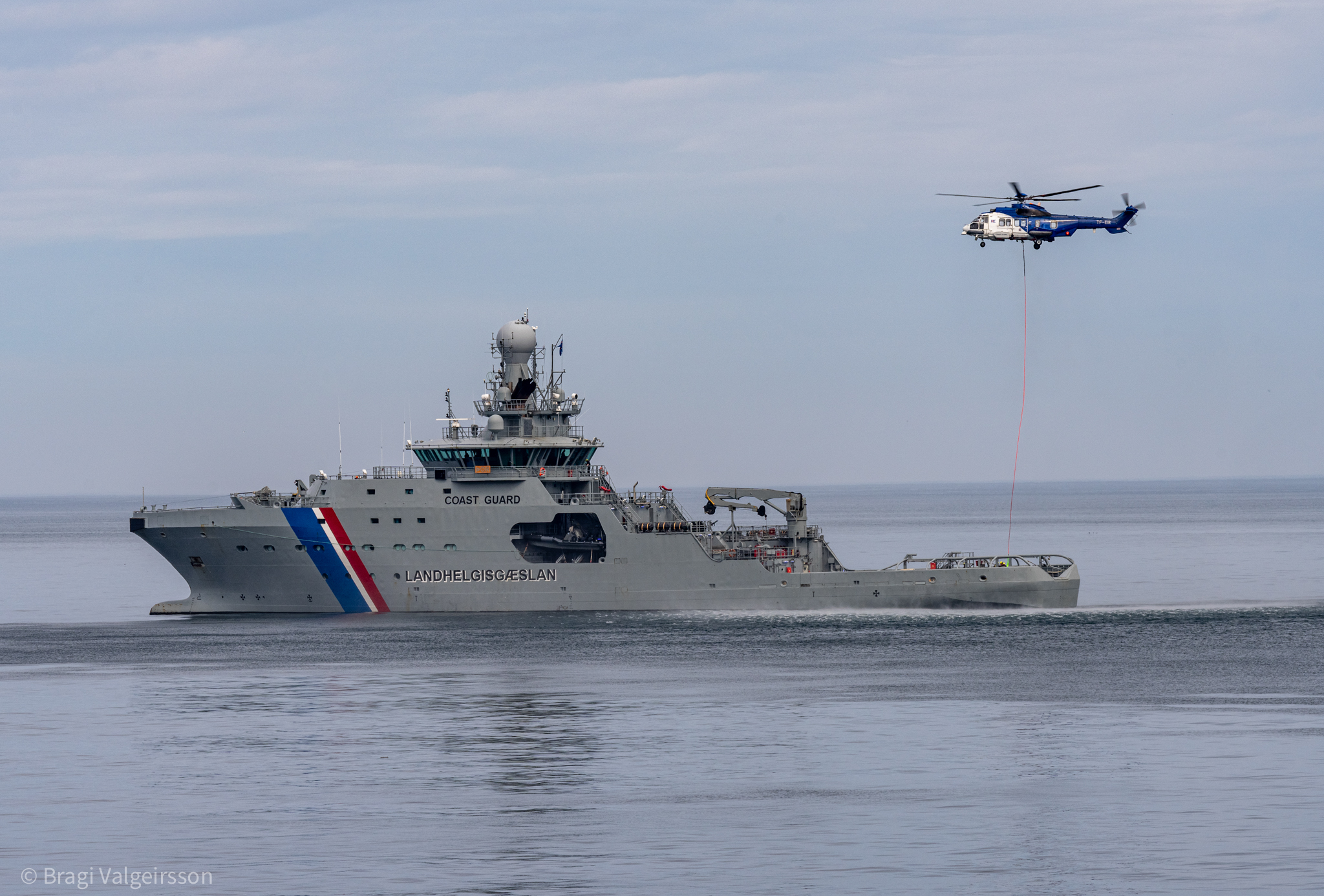Varðskipið Þór og þyrla Landhelgisgæslunnar við Melrakkanes þar sem þyrlan flutti rafgeyma í vitann. Mynd: Bragi Valgeirsson