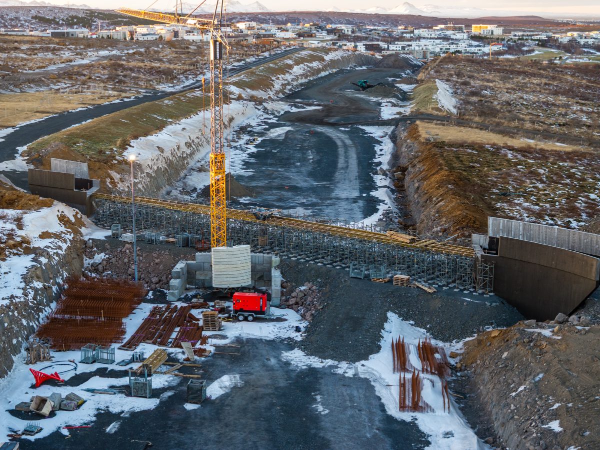 Uppsteypu stöpla fyrir nýja göngubrú yfir Arnarnesveg, til móts við Turnahvarf, er lokið og unnið er við undirslátt brúardekksins.
